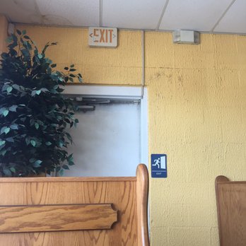 Johnny's Pizza House - The dirty mildew and molded wall and door behind our booth - Pizza Near Me - Baton Rouge, Louisiana