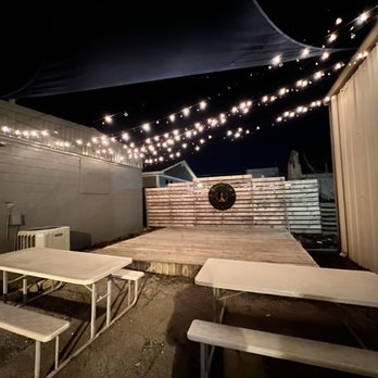 InnerSpace Brewing - a patio with tables, benches, and string lights - Breweries Near Me - Huntsville, Alabama