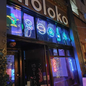 Moloko - a neon sign on the front of a restaurant - Lounges Near Me - Portland, Oregon