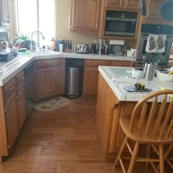 PCS Flooring - a kitchen with wooden cabinets and a white countertop - General Contractors Near Me - Temecula, California