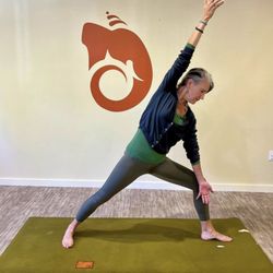 Om Namo Center - Sally in Warrior pose in front of our beautiful Ganesh symbol~ check out our full schedule of classes!