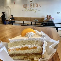 House Cake - Vanilla cake with dulce de leche, whipped cream, & peaches. Crunchy merengue exterior. House Cake - Vanilla cake with dulce de leche, whipped cream, & peaches. Crunchy merengue exterior.