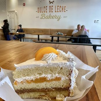 Dulce de Leche Bakery - House Cake - Vanilla cake with dulce de leche, whipped cream, & peaches. Crunchy merengue exterior. - Bakeries Near Me - Jersey City, New Jersey