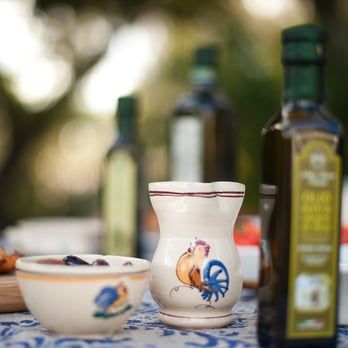 Le Sorelle - a table with a bowl of soup and a bottle of olive oil - Specialty Food Near Me Le Sorelle - a table with a bowl of soup and a bottle of olive oil - Specialty Food Near Me