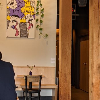 Deep City - a man sitting at a table in a restaurant - New American Near Me - Burlington, Vermont