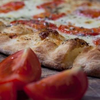 Gino’s Pizza - Ida - a pizza with tomatoes and cheese - Pizza Near Me - Ida, Michigan