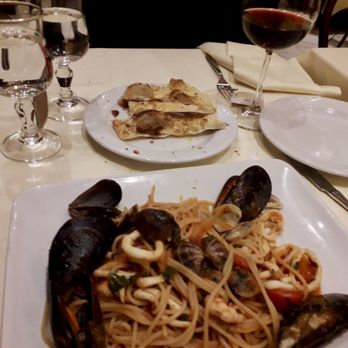 Settembrini 18 - Seafood pasta, glass of red wine, warm toasted bread slices in the middle. - Italian Near Me - Milan, Michigan Settembrini 18 - Seafood pasta, glass of red wine, warm toasted bread slices in the middle. - Italian Near Me - Milan, Michigan