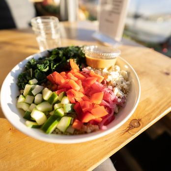 WildFlour Cafe & Bakery - Signature Lunch Bowl: Quinoa, kale, cucumber, bell pepper, cherry tomato, pickled red onion, and feta with a garlic tahini sauce. - Juice Bars & Smoothies Near Me - Sitka, Alaska WildFlour Cafe & Bakery - Signature Lunch Bowl: Quinoa, kale, cucumber, bell pepper, cherry tomato, pickled red onion, and feta with a garlic tahini sauce. - Juice Bars & Smoothies Near Me - Sitka, Alaska