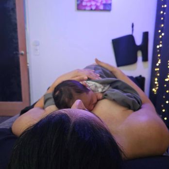 Sacred Space Massage and Bodywork - On massage table while holding baby for postpartum massage. - Massage Near Me - Whittier, California Sacred Space Massage and Bodywork - On massage table while holding baby for postpartum massage. - Massage Near Me - Whittier, California