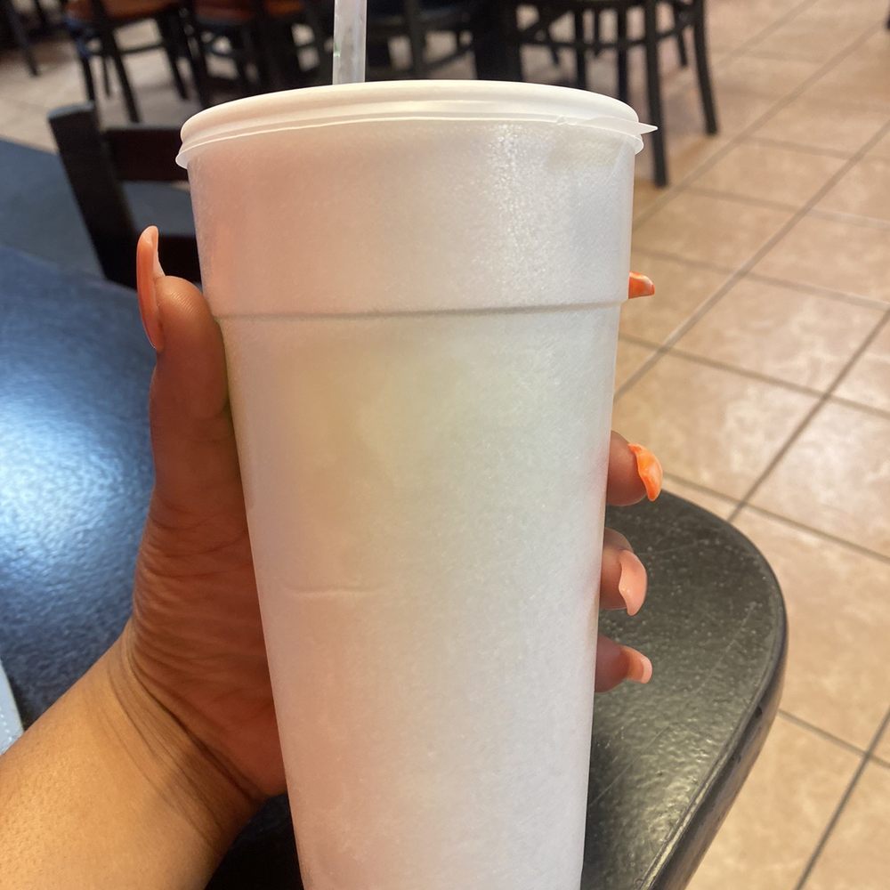 a hand holding a plastic cup with a straw