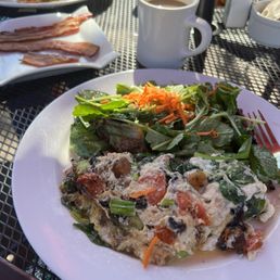 Farm fresh omelet, bacon, and smothered hash browns in the background