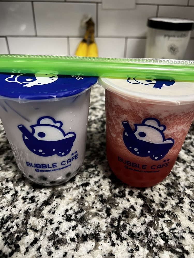 Two boba cups on a granite counter top.
