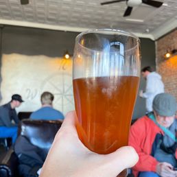 a person holding a glass of beer a person holding a glass of beer