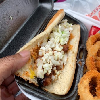 Cook Out - a person holding a hot dog and onion rings - Hot Dogs Near Me - Huntersville, North Carolina Cook Out - a person holding a hot dog and onion rings - Hot Dogs Near Me - Huntersville, North Carolina