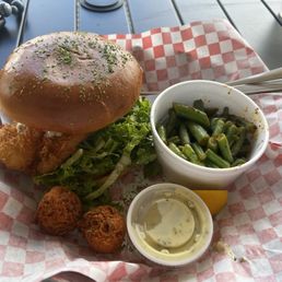 Fish sandwich with green beans on the side Fish sandwich with green beans on the side