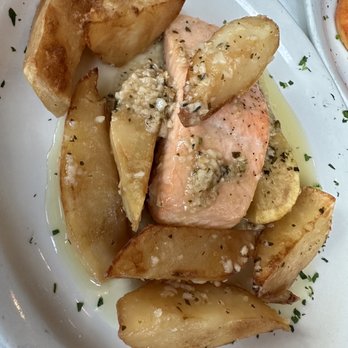 Caro Mio - Salmone Vesuvio - Salmon fillet served with roasted potato wedges, topped with garlic and herbs, on a white plate. - Italian Near Me - Chicago, Illinois