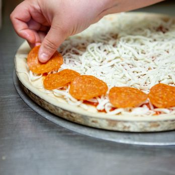 Rocko's Pizza - a person making a pizza - Pizza Near Me - Terrell, Texas Rocko's Pizza - a person making a pizza - Pizza Near Me - Terrell, Texas