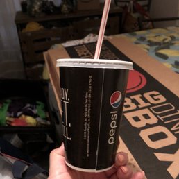 a hand holding a cup with a straw