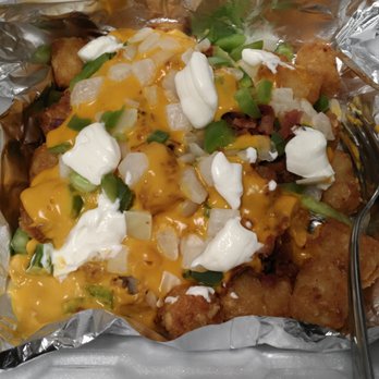 Val's Pizza - Smothered tots. Bacon, cheese sauce, onions, green peppers and sour cream on a generous portion of tater tots. - Pizza Near Me - Owosso, Michigan