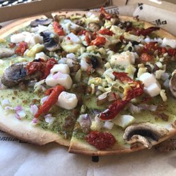 Gluten free crust with pesto, sundries tomatoes, mushrooms, vegetarian sausage, artichoke heart, garlic and vegan cheese Gluten free crust with pesto, sundries tomatoes, mushrooms, vegetarian sausage, artichoke heart, garlic and vegan cheese