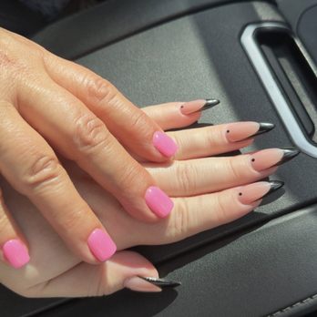 Flashy Nails - Third visit and it is a charm ! Pretty dip pink for mom and gel x for my daughter  Love this place - A hand with manicured nails, featuring pink polish on some fingers and black-tipped designs on others, rests on a car dashboard. - Nail Salons Near Me - Albuquerque, New Mexico