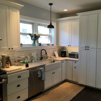 Marte Construction - a kitchen with white cabinets and stainless steel appliances - General Contractors Near Me