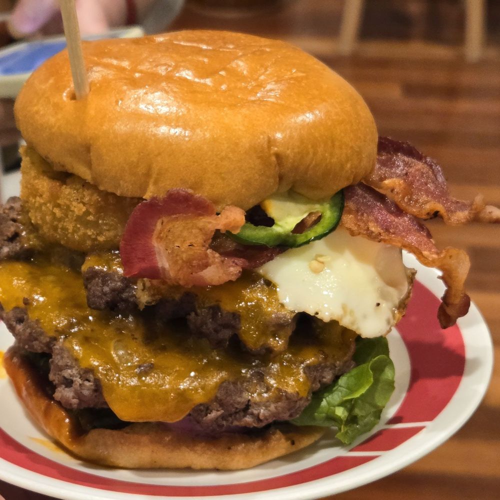 Sunrise Burger with extra patty, extra cheese, extra bacon, and onion ring topper.