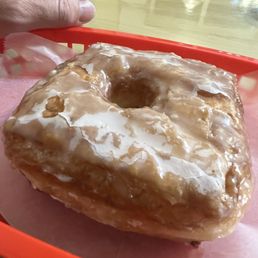 a hand holding a glazed donut a hand holding a glazed donut
