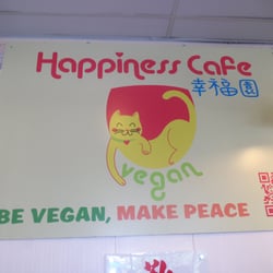 Happiness Cafe - A board in their vegan cafe with their logo