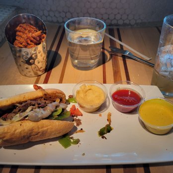 Root Down DIA - Cheese steak sandwich, sweet potato fries, and a Long Island. Super fast with the order. The beef is so tender! - New American Near Me - Denver, Colorado