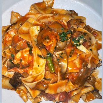 Delfino - A serving of pasta with tomato-based sauce, garnished with chopped herbs and mixed vegetables, on a white plate. - Italian Near Me - Roslindale, Massachusetts