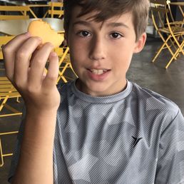 a young boy holding a macaron a young boy holding a macaron