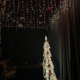 a lighted christmas tree in a dark room a lighted christmas tree in a dark room