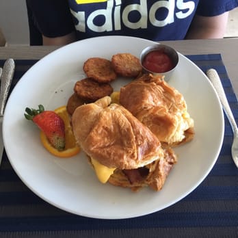 Latitudes - Croissant with bacon eggs and cheese. Side of potato pancakes - Seafood Near Me - Highland Beach, Florida