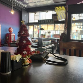 Lindy's Diner - Inside view - A miniature Christmas tree with a star on top and snowflake ornaments sits on a table inside a cafe, with a purse and condiments nearby. - Diners Near Me - Albuquerque, New Mexico