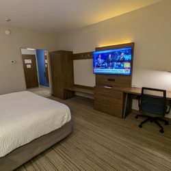 Holiday Inn Express & Suites Macon North - Room 415. Closet, luggage counter, hanger hooks, adjustable TV, office desk, dresser.