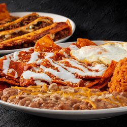 Fuego Cravings - Chilaquiles topped with creamy crema, a fried egg, rice & beans, the perfect way to start your morning!