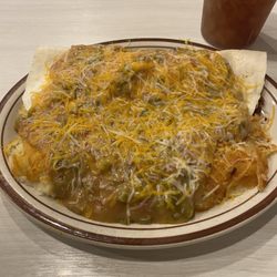 Weck's - Bacon breakfast burrito smothered in Green Chili served with smothered hashbrowns