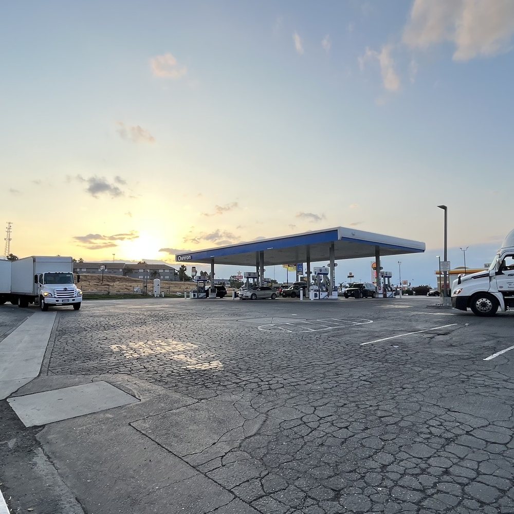 a gas station with trucks parked in a parking lot a gas station with trucks parked in a parking lot