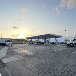 a gas station with trucks parked in a parking lot a gas station with trucks parked in a parking lot
