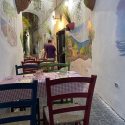 Osteria dei Sapori - You are sitting in a narrow walkway. The kitchen is in the doorway on the right.