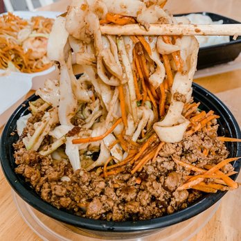 Chef Hong - Noodles with meat and black bean sauce - A bowl of Asian-style noodles topped with ground meat, shredded carrots, and vegetables, with chopsticks lifting some noodles. - Chinese Near Me - Austin, Texas