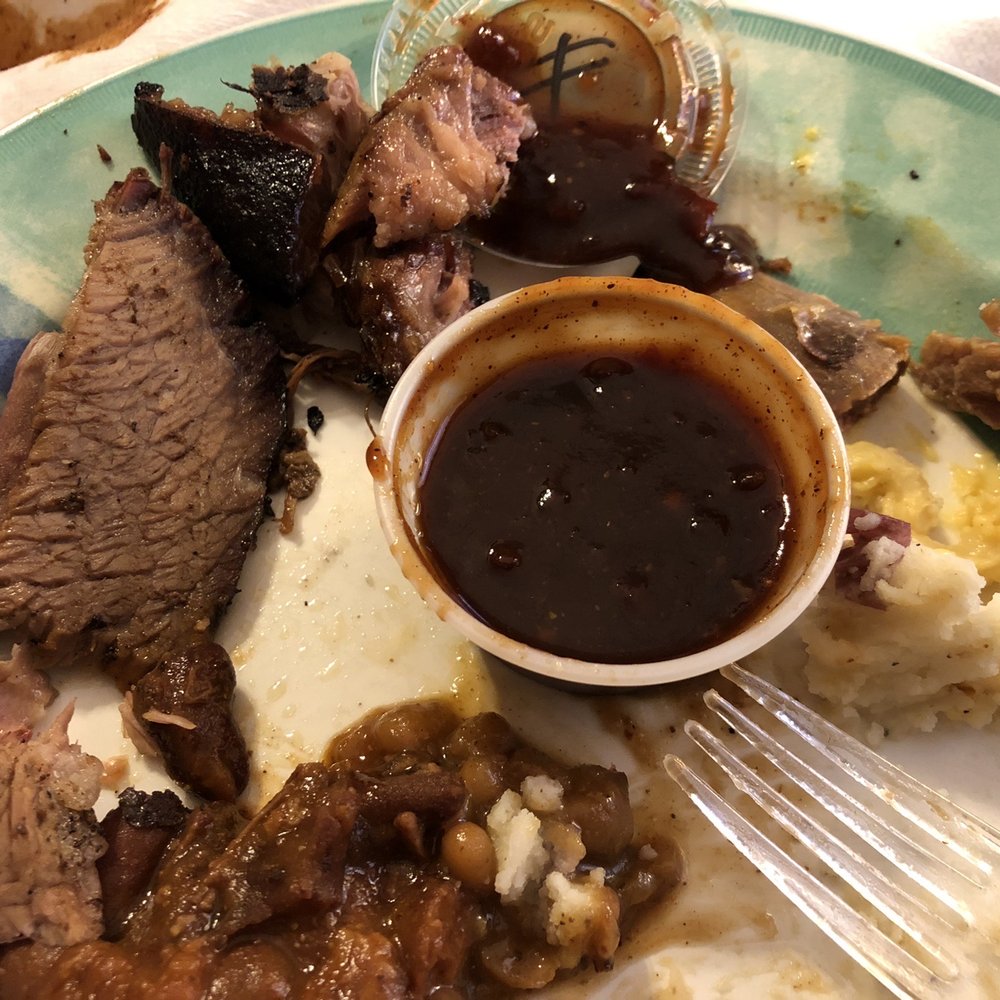 Half eaten plate. Cw: Burnt ends, pulled pork,  Mac and cheese, mashed potatoes, beans, chili, brisket and rib remnants.