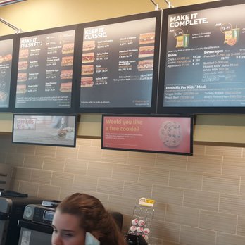 Subway - a woman sitting at a counter in front of a menu - Sandwiches Near Me - Jefferson City, Missouri Subway - a woman sitting at a counter in front of a menu - Sandwiches Near Me - Jefferson City, Missouri