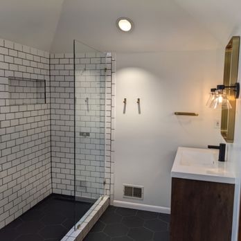 Rehome Renovation - Finished modern bathroom update with subway-tiled walk-in shower, black hexagonal floor tile, glass panel and new vanity - General Contractors Near Me Rehome Renovation - Finished modern bathroom update with subway-tiled walk-in shower, black hexagonal floor tile, glass panel and new vanity - General Contractors Near Me