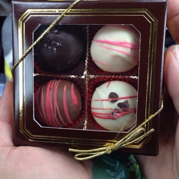 Mostly Chocolates - a person holding a box of chocolates - Candy Stores Near Me - Rapid City, South Dakota