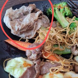 Beef chowmein with a napkin buried in the middle of the dish. Beef chowmein with a napkin buried in the middle of the dish.