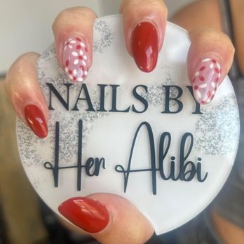 Her Alibi Salon - Red nails with two of them with red and white petals. Very demure - Hair Salons Near Me - Helena, Montana