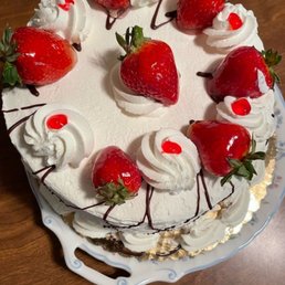 Shortcake - A strawberry shortcake with whipped cream, fresh strawberries, and red cherry toppings, presented on a decorative plate.