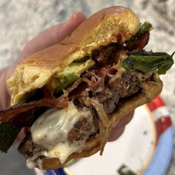 Matty’s Patty’s - ows a hand holding a sandwich - Burgers Near Me - Cypress, Texas